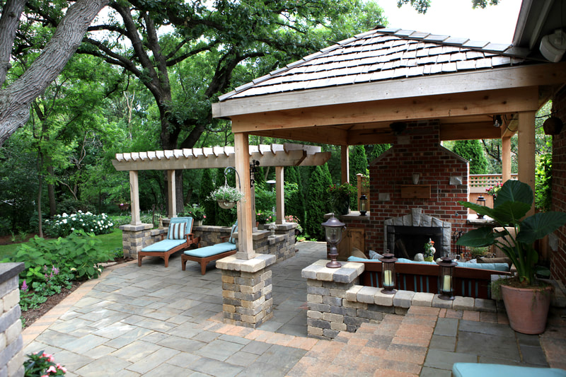 large covered backyard lounge area with fire pit and chimney