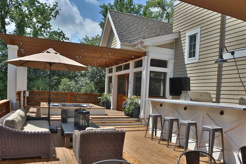 back patio with furniture, bar and house in background