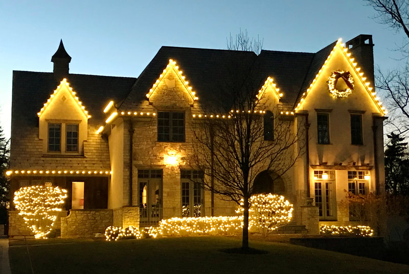 front of home at dusk with white holiday lights on trim
