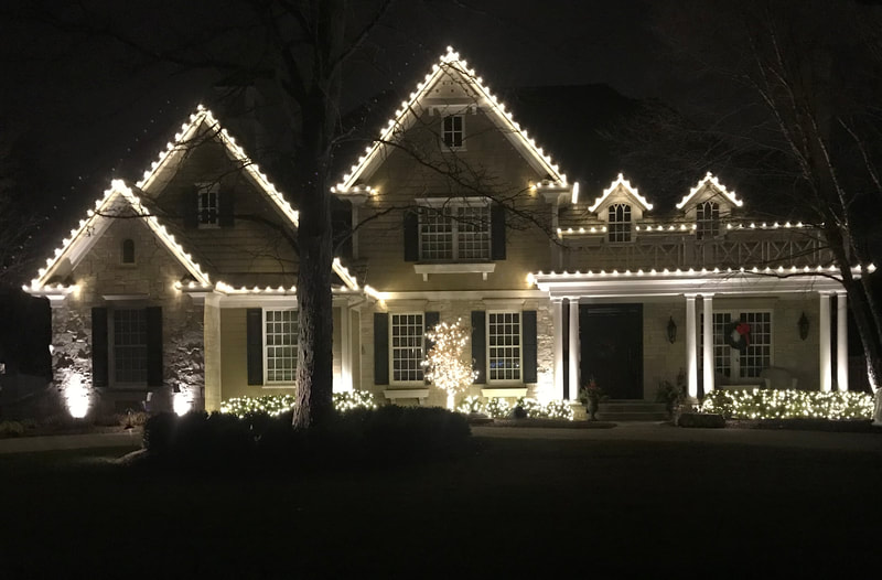 large home with holiday lights around the trim