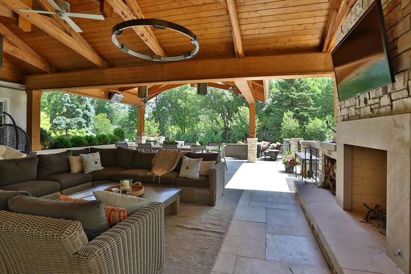 covered back patio with fireplace and couches
