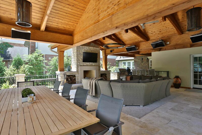 outdoor patio with long table, furniture and fireplace