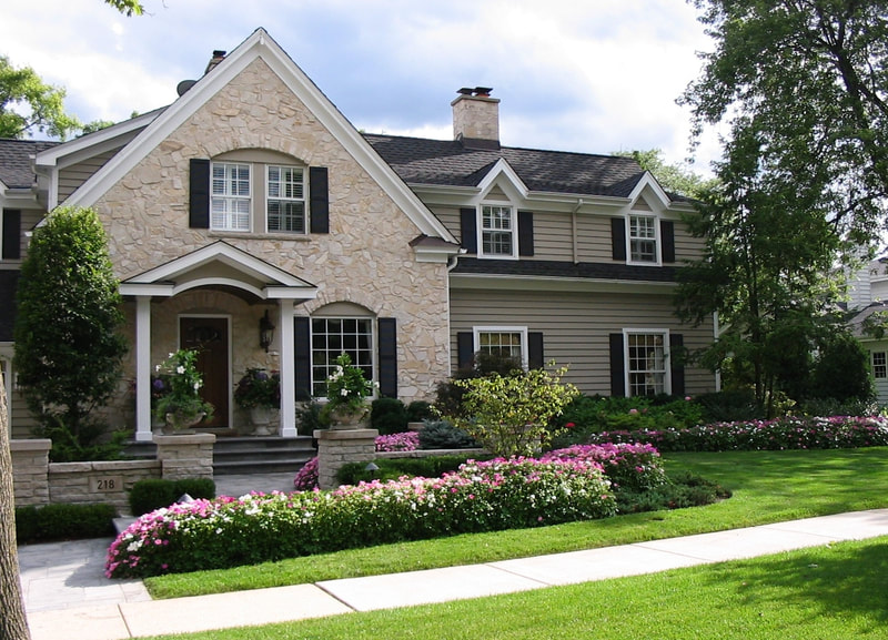 wide shot of beautiful house with manicured lawn and garden