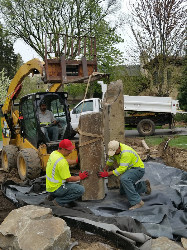 construction workers removing stone with backhoe
