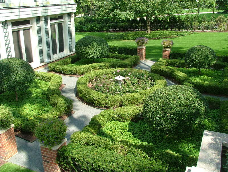 backyard garden with circular walking path and tall shrubs